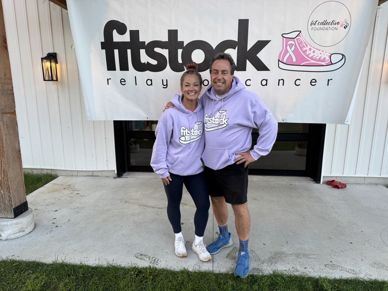 Two FITSTOCK organizers in event hoodies under the FITSTOCK banner